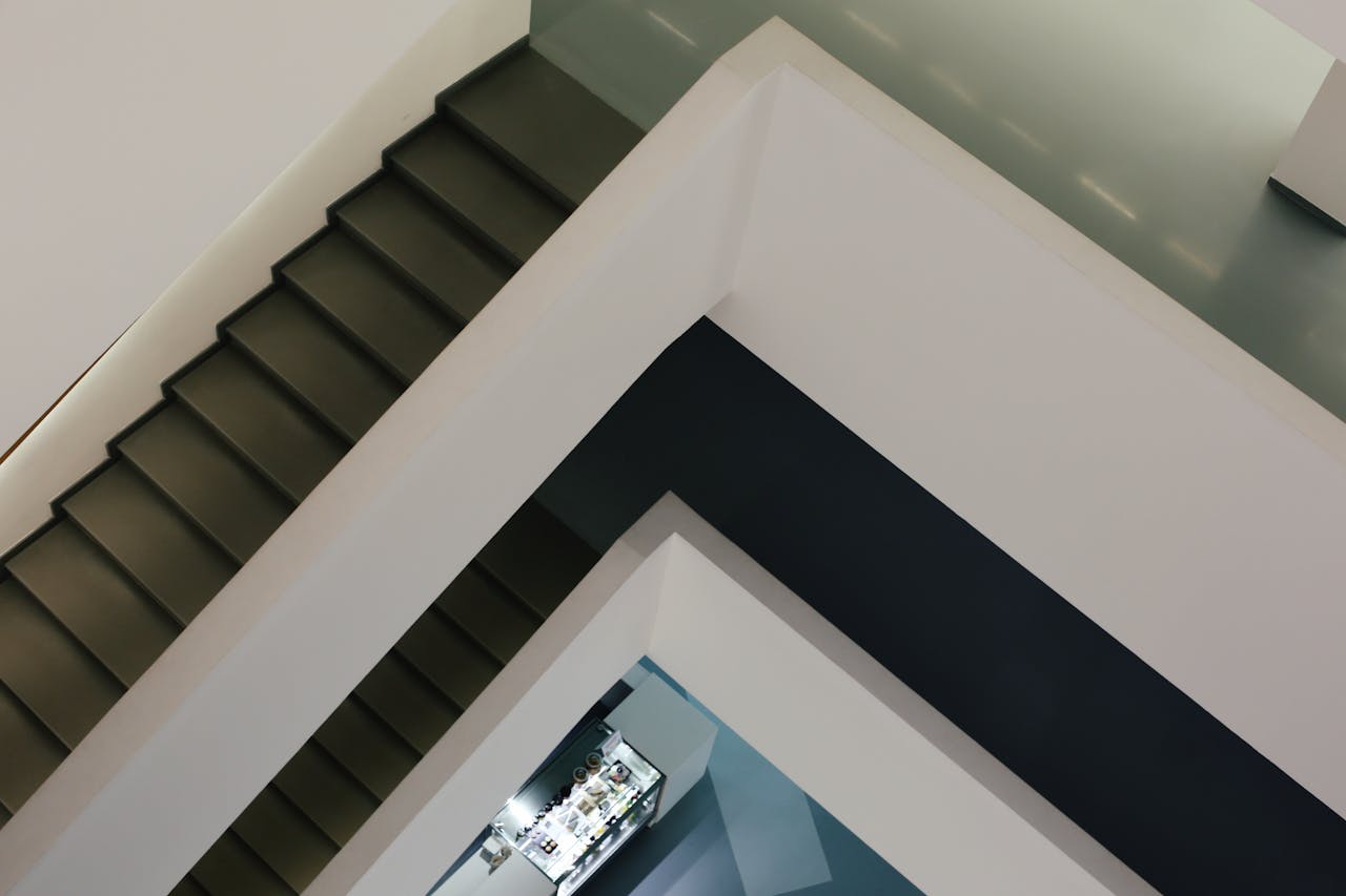 why-choose-us A modern interior showcasing a minimalist staircase with contrasting black and white colors.
