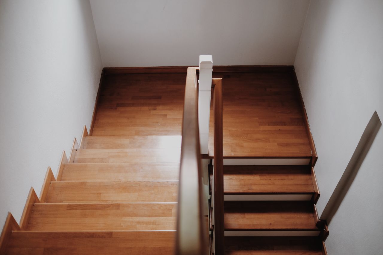 gallery-1 Top view of a wooden staircase in a minimalist interior, showcasing clean lines and elegant design.