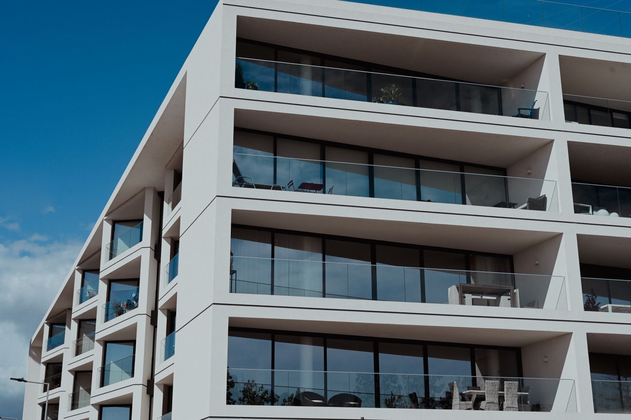services-02 Contemporary apartment building in Faro, featuring sleek balconies and clear blue skies.