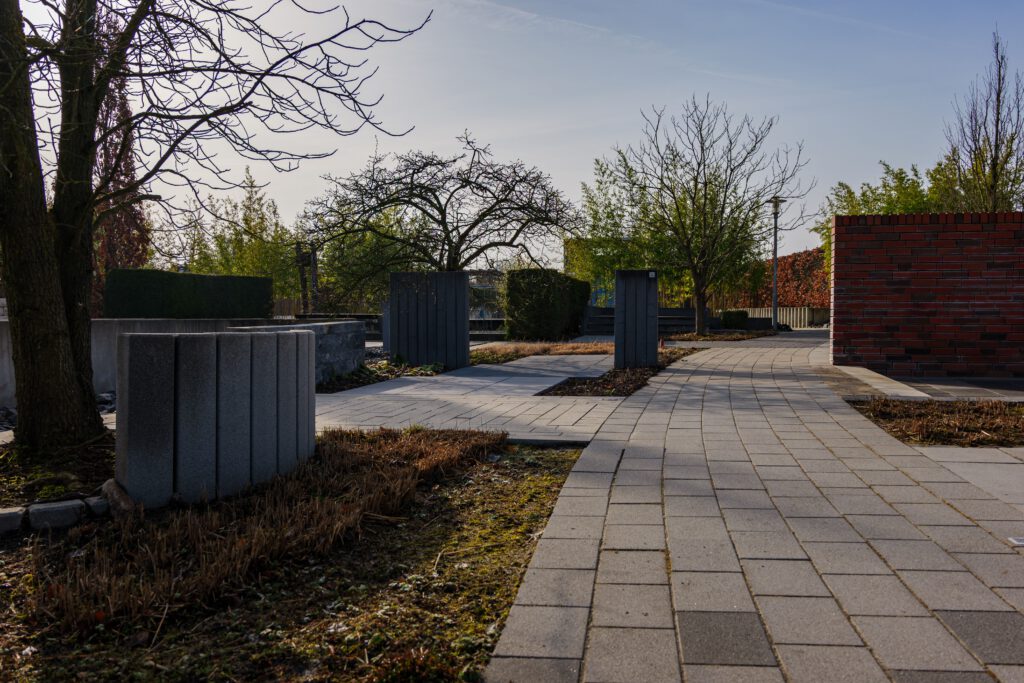 Peaceful cemetery walkway with trees and modern design in Coesfeld, Germany.