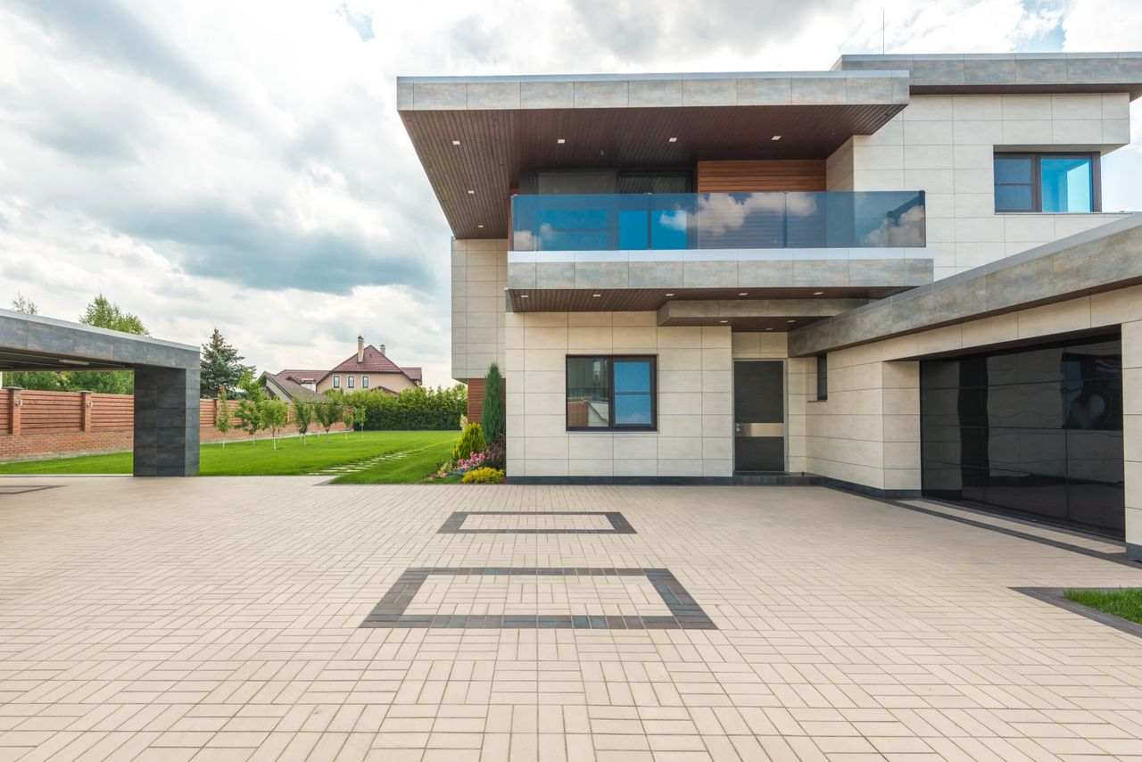 services-03 Stylish modern house featuring a sleek design with a large driveway and lush greenery.